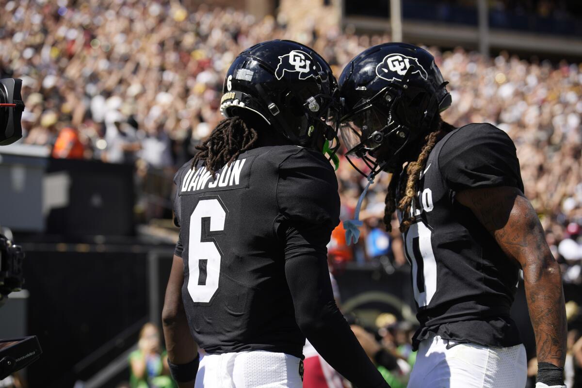 Colorado wide receiver Tar'Varish Dawson is congratulated by wide receiver Xavier Weaver after scoring a touchdown.