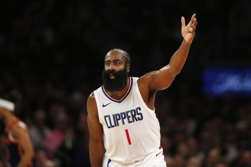 Clippers guard James Harden holds up three fingers after making a three-point shot.