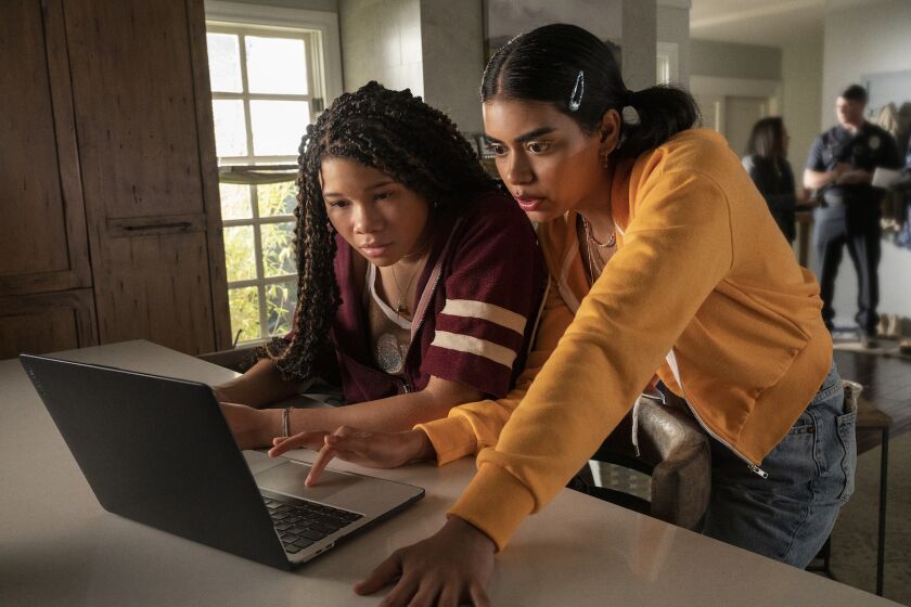 Two high school girls working on a laptop computer in the movie "Missing."