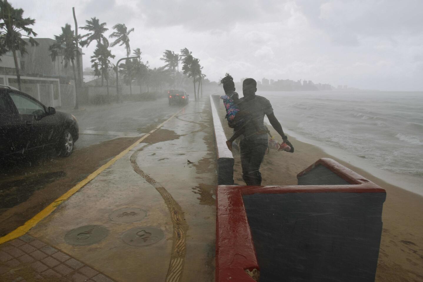 A man and his daughter flee from the rain on a San Juan beach before Hurricane Maria's arrival.