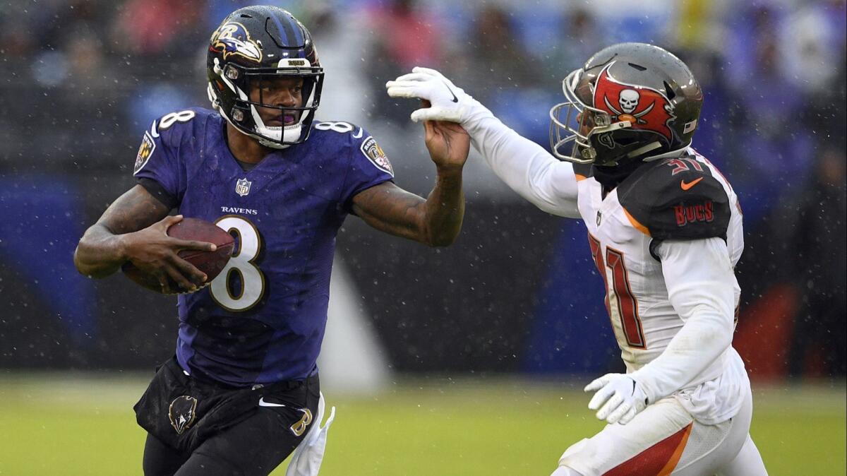 Baltimore quarterback Lamar Jackson, left, rushes against Tampa Bay's Jordan Whitehead during a game on Dec. 16. Jackson is his team’s leading rusher, with 566 yards this season