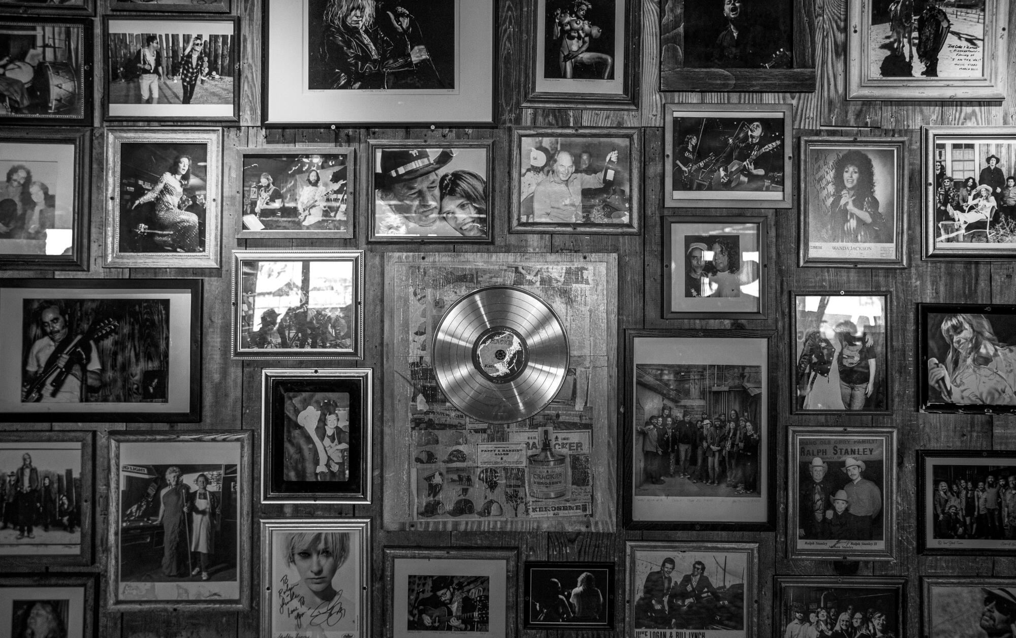 A wall containing photos and artifacts of musical artists who have performed at a nightclub.