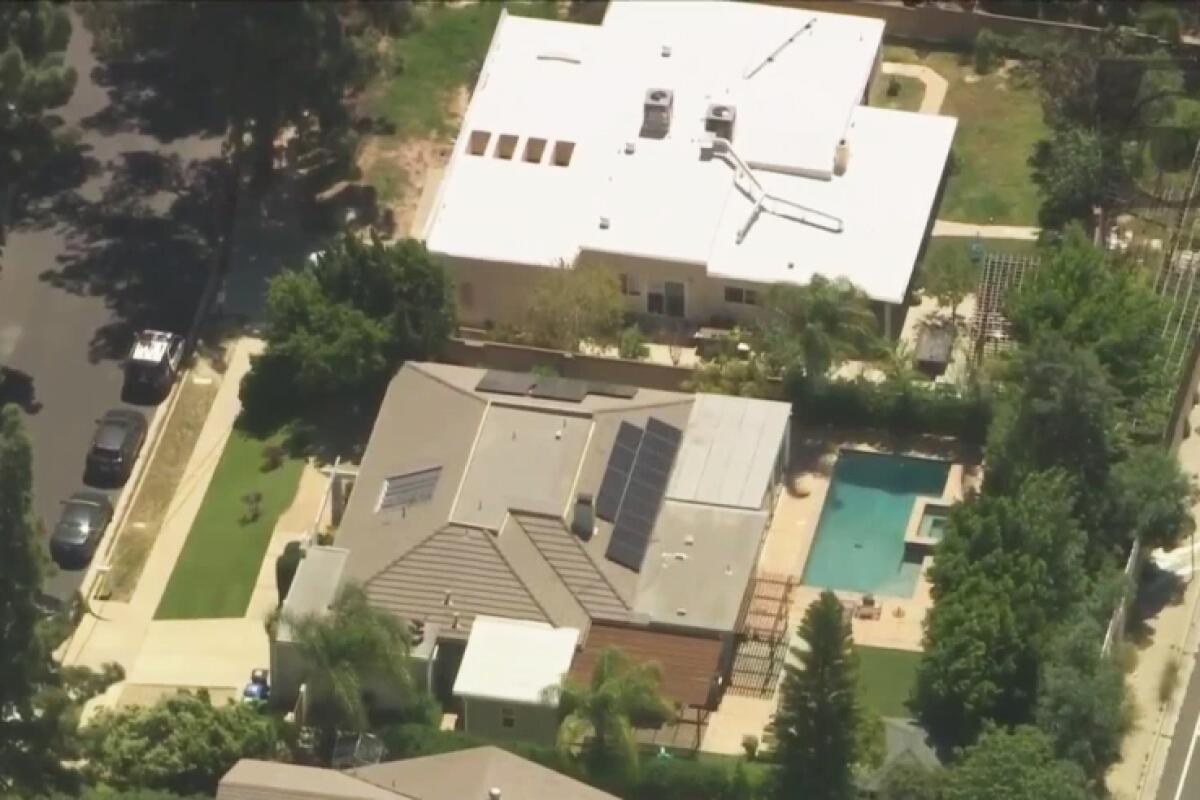 An aerial view of a home with a backyard swimming pool.