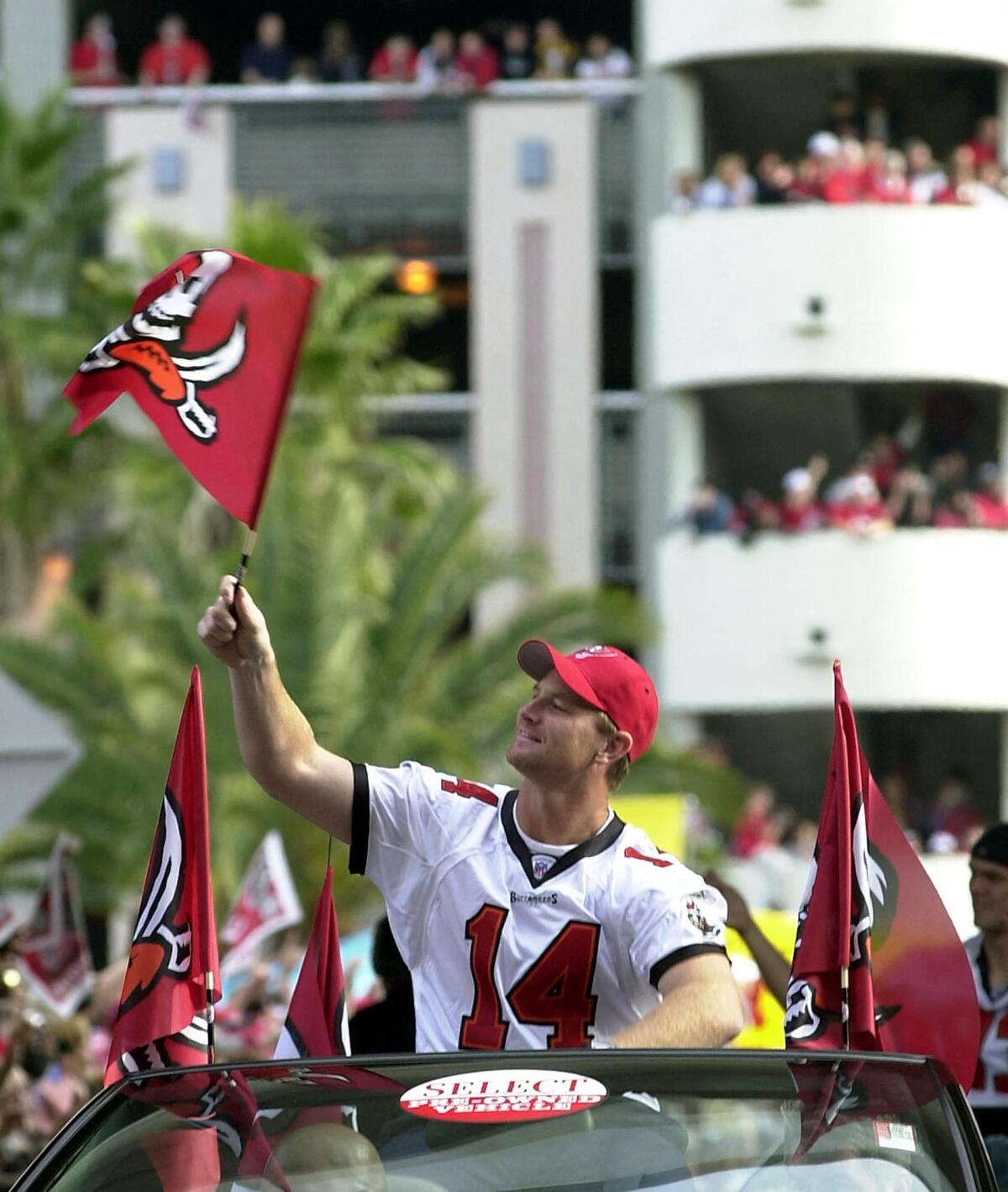 Buccaneers' quarterback Brad Johnson waves a team flag to the crowd during a Super Bowl victory parade in 2003.