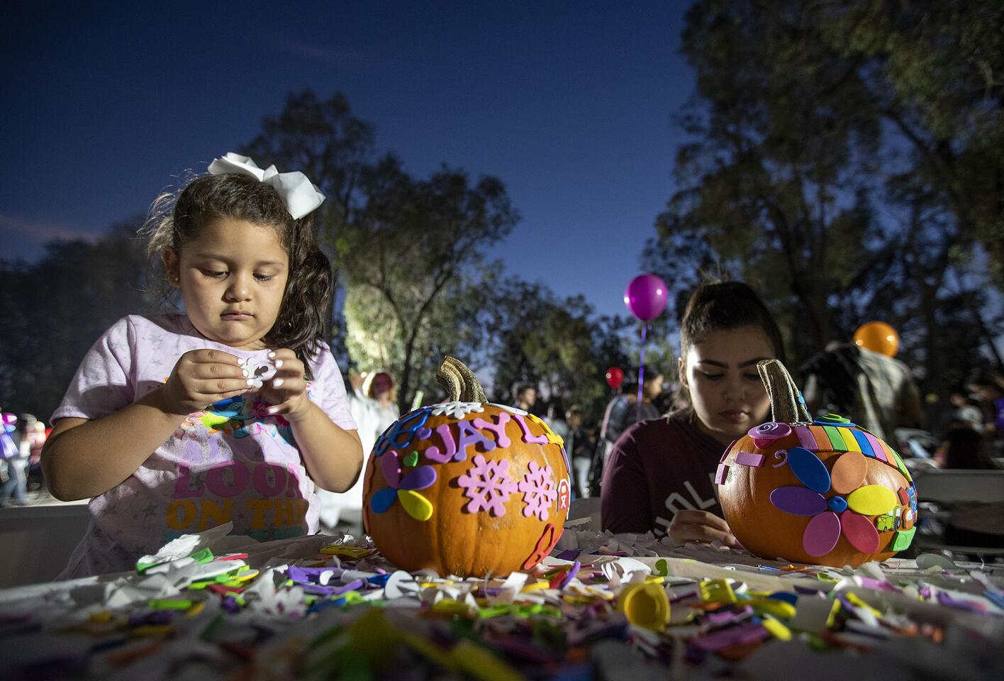 Sisters Jaylin Medina, 5, and Sierra Medina, 15, decorate pumpkins on Thursday during the annual pumpkin patch and pumpkin giveaway event sponsored by Torelli Realty in Costa Mesa.