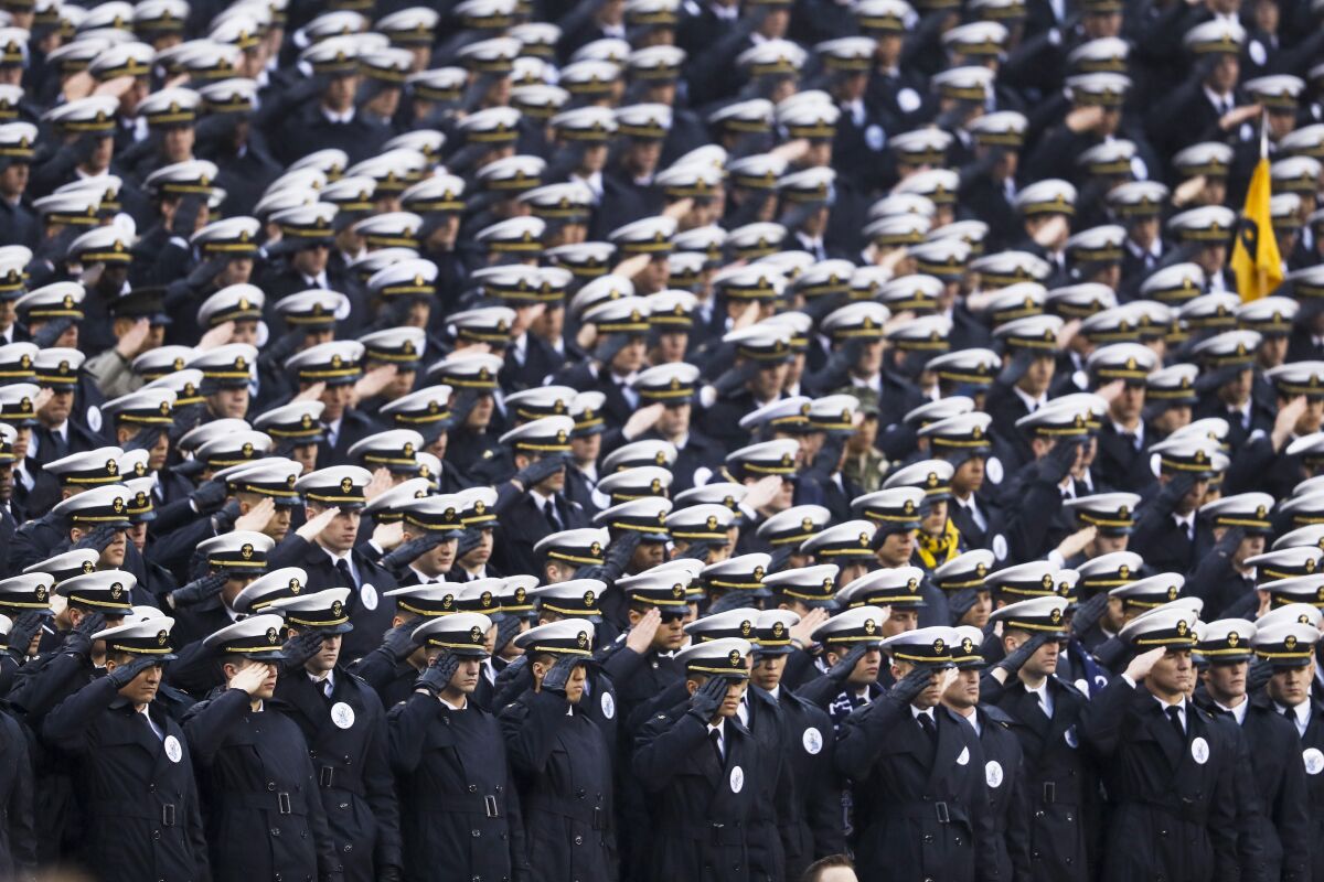 Naval Academy midshipmen salute ahead of a game against Army in Philadelphia on Saturday.