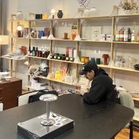 A man sips coffee in a lifestyle store and coffee house.