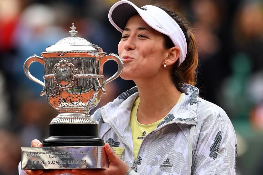 Garbine Muguruza kisses the winner's trophy after defeating Serena Williams in the French Open final on Saturday.