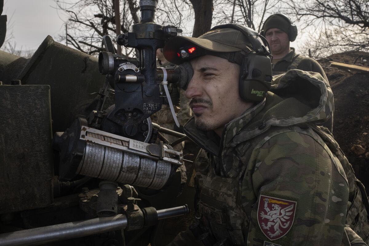 A Ukrainian soldier fires a D-30 cannon towards Russian positions.