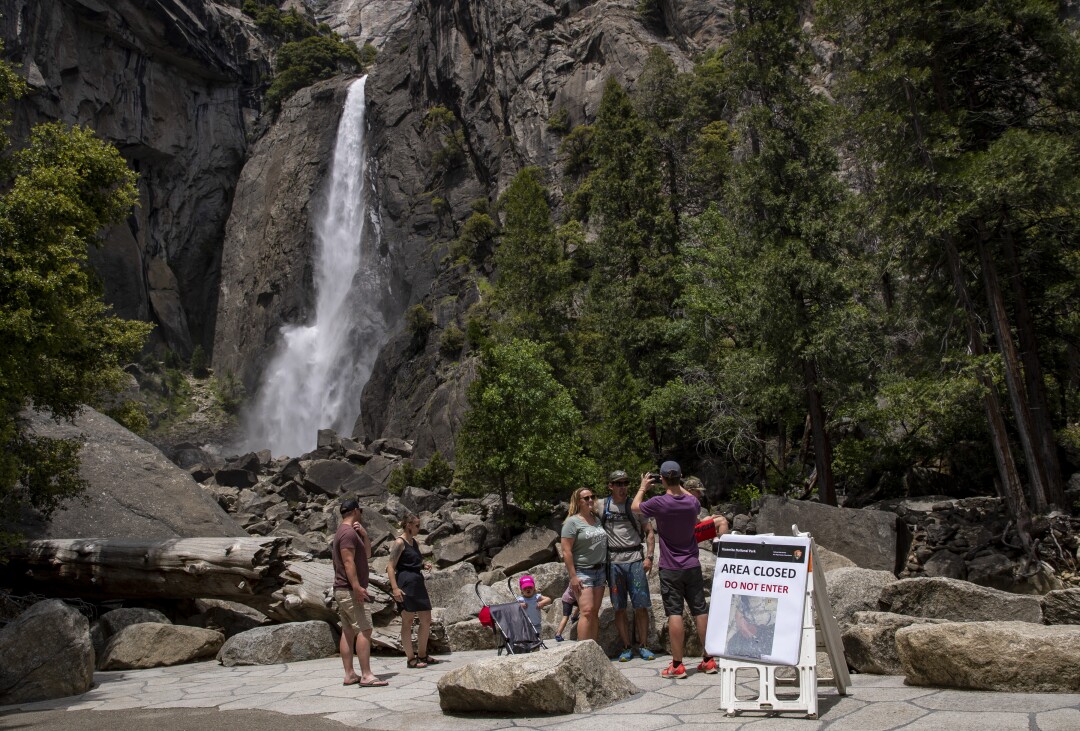 Visitors to Yosemite Valley take photographs at Lower Yosemite Falls.