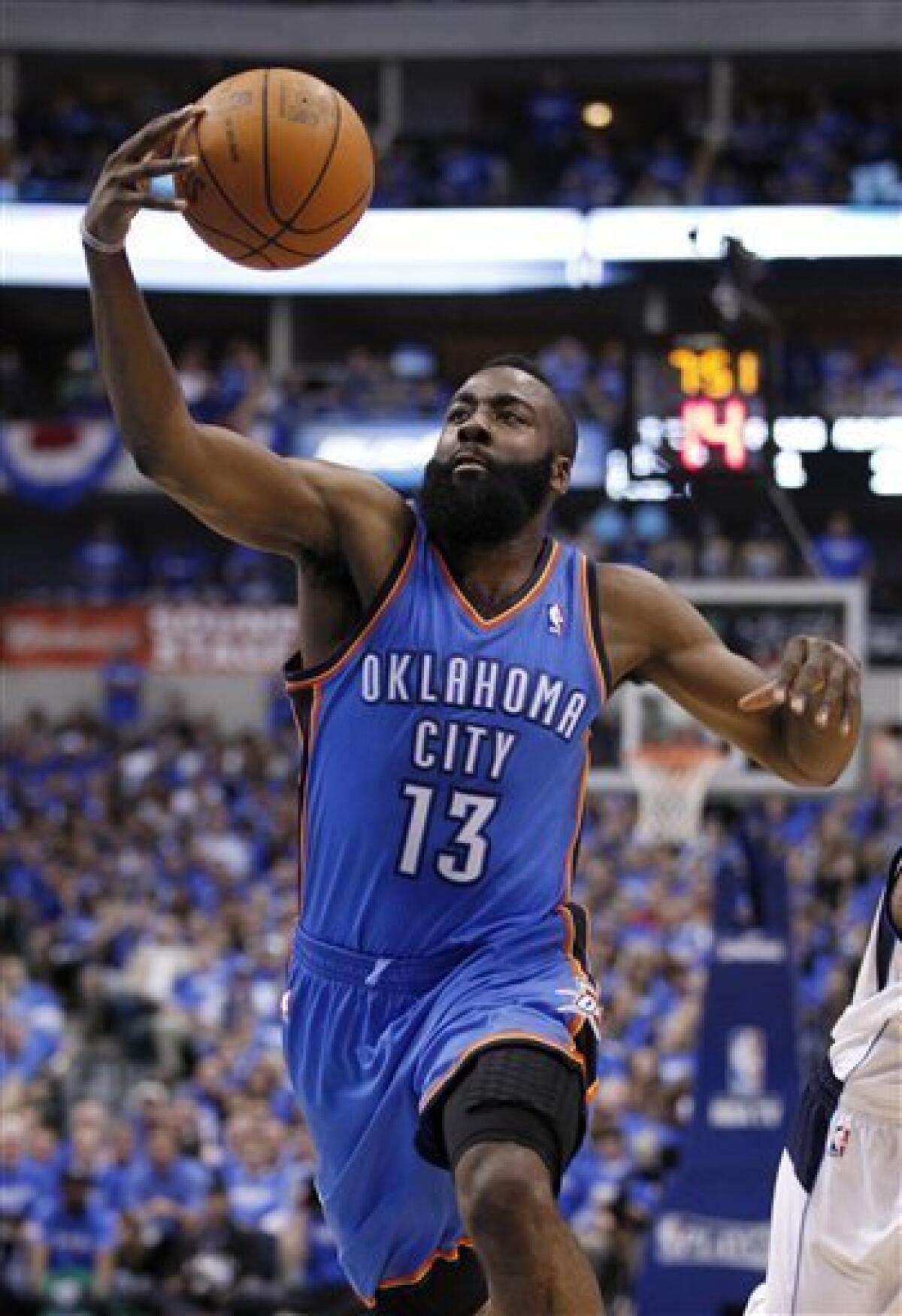 In this May 3, 2012 photo, Oklahoma City Thunder's James Harden (13) grabs a loose ball against the Dallas Mavericks during Game 3 in the first round of the NBA basketball playoffs in Dallas. The Thunder have traded Sixth Man of the Year Harden to the Houston Rockets, breaking up the young core of the Western Conference champions. The Thunder acquired guards Kevin Martin and Jeremy Lamb, two first-round picks and a second-round pick in the surprising deal that was completed Saturday night, Oct. 27, 2012. Oklahoma City also sent center Cole Aldrich, and forwards Daequan Cook and Lazar Hayward to Houston. (AP Photo/Tony Gutierrez)