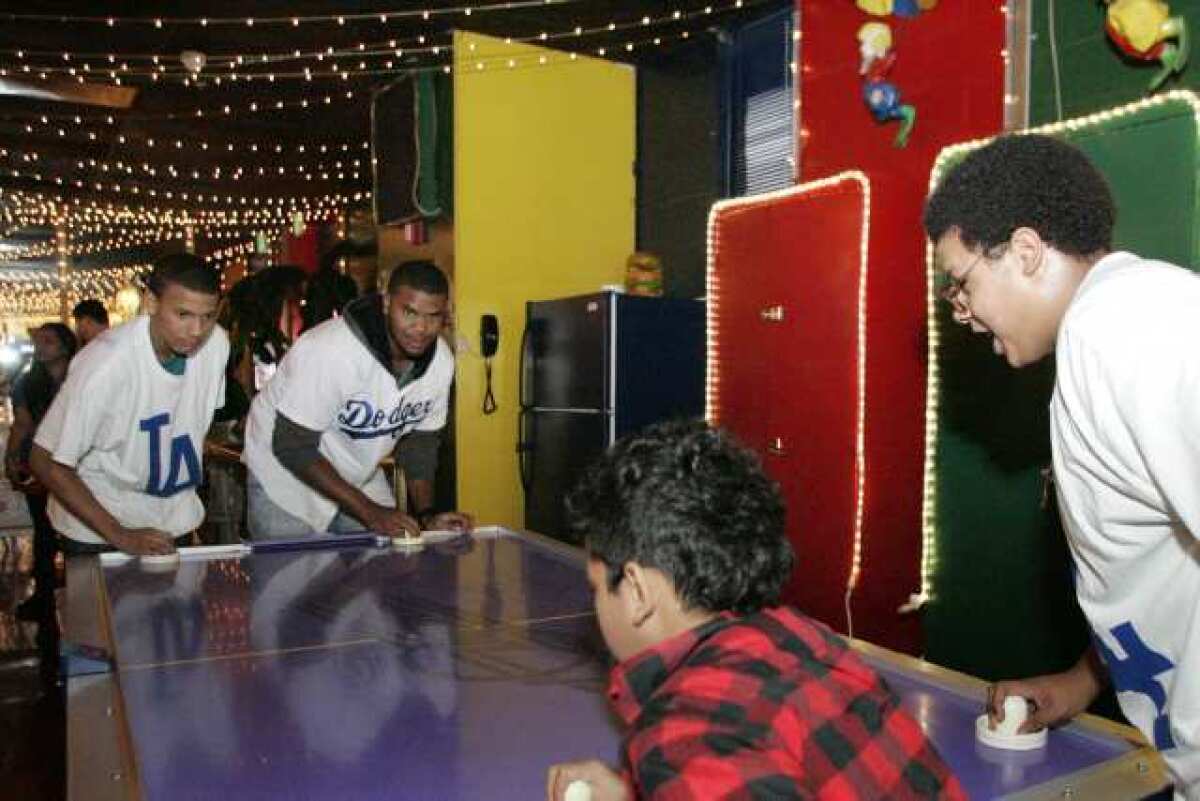 Marquise Patterson, left, teams up with the LA Dodgers' Kenley Jansen for a round of air hockey at Tobinworld in Glendale.
