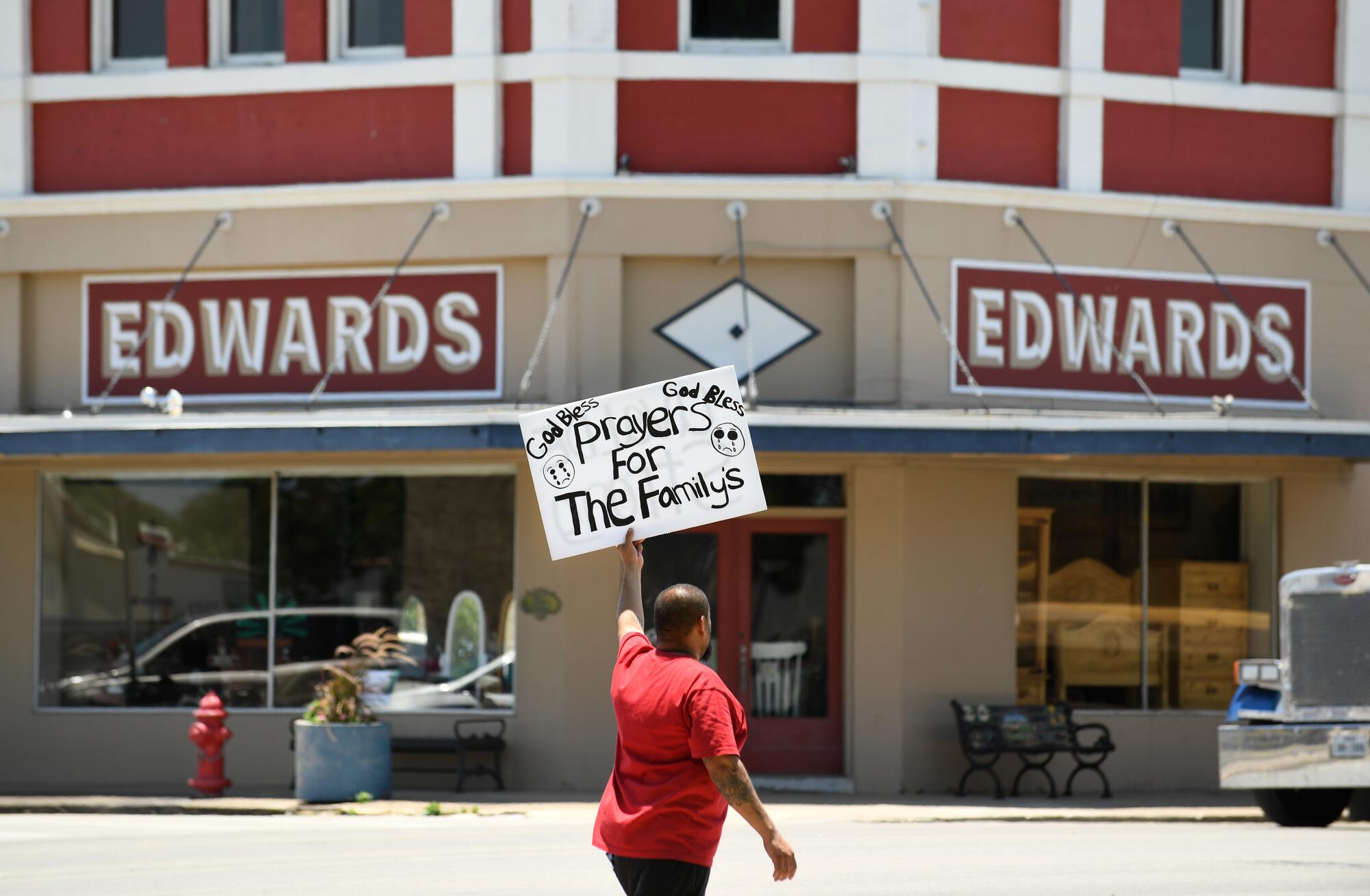 Alex Covarrubias carries a sign in town for the victims of the school shooting in Uvalde, Texas.