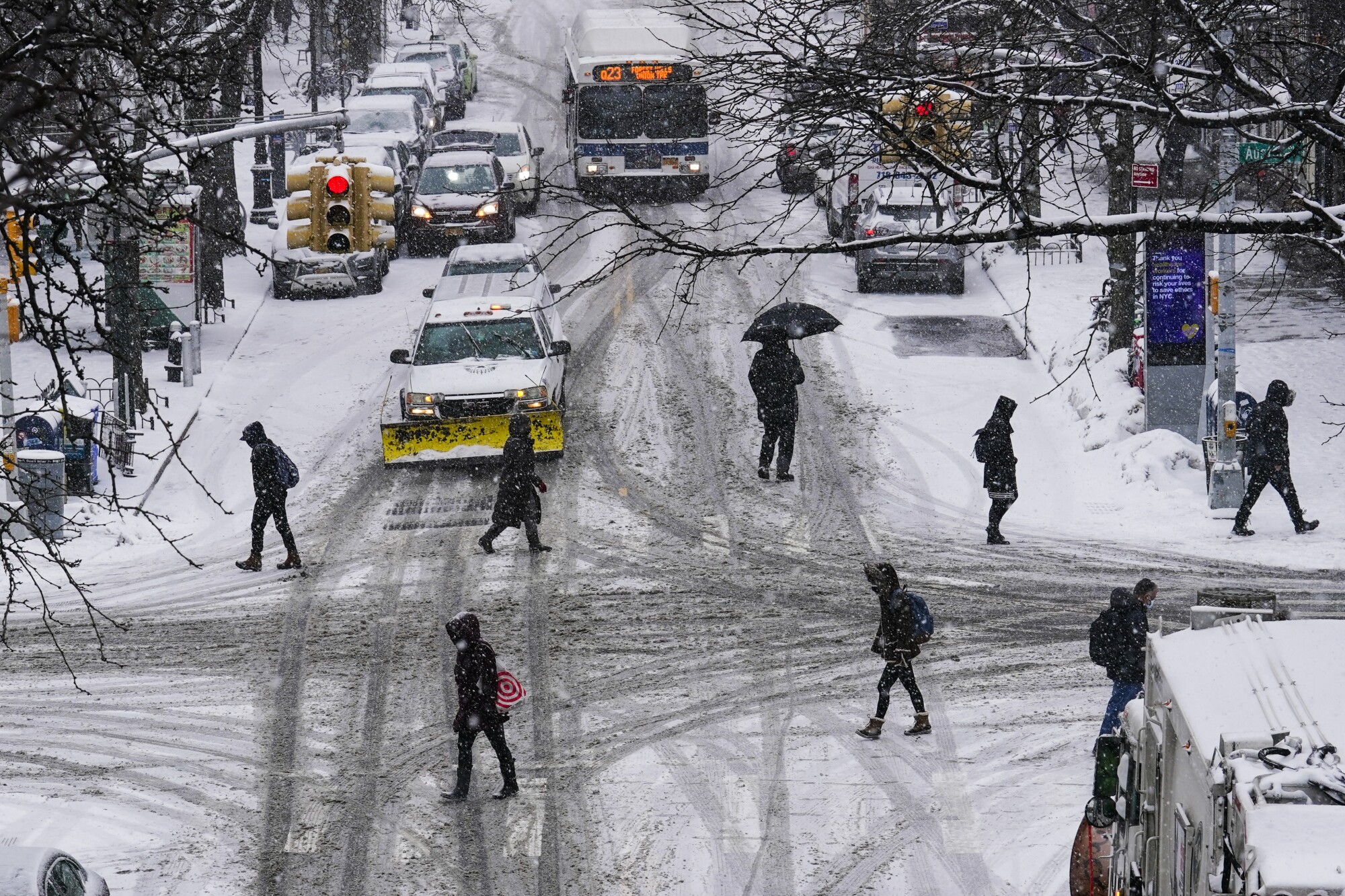 Pedestrians cross a snowy street in New York City. 