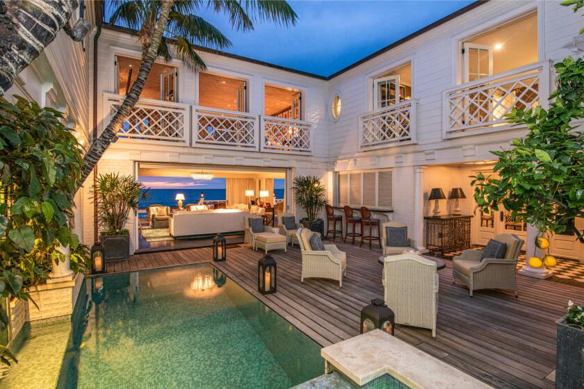 The two-story home enjoys ocean views from multiple balconies and an entertainer's deck that sits above the sand.
