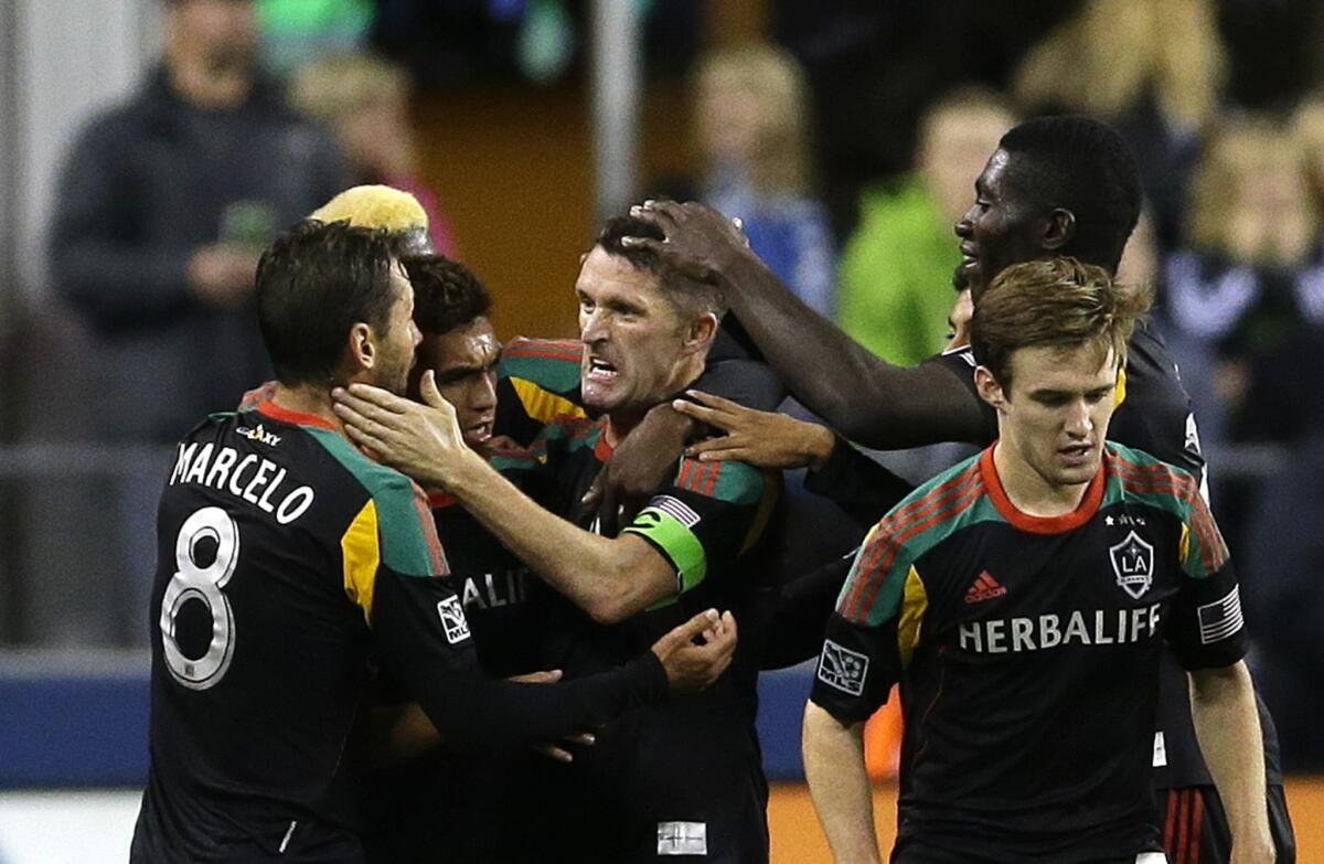 Galaxy forward Robbie Keane, center, celebrates with his teammates after scoring a goal against the Seattle Sounders on Sunday. The Galaxy open the playoffs Saturday against Real Salt Lake.