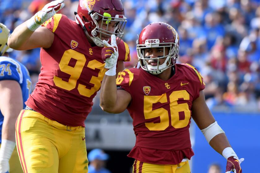Jordan Iosefa (56) celebrates a sack with Liam Jimmons (93) during the first half of a game against the UCLA on Nov. 17, 2018 at the Rose Bowl. 