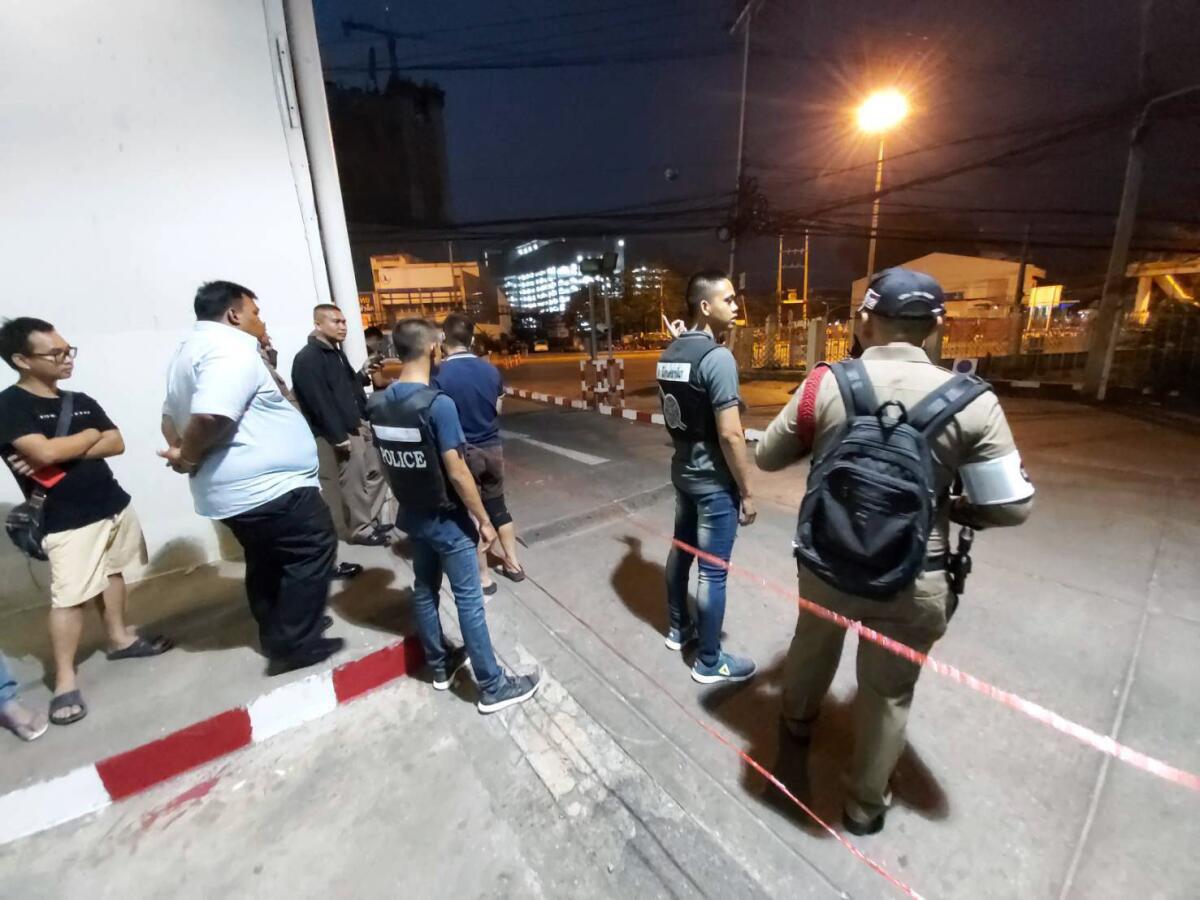 Police and bystanders near the scene of a mass shooting Saturday at the Terminal 21 mall in Nakhon Ratchasima, Thailand. 