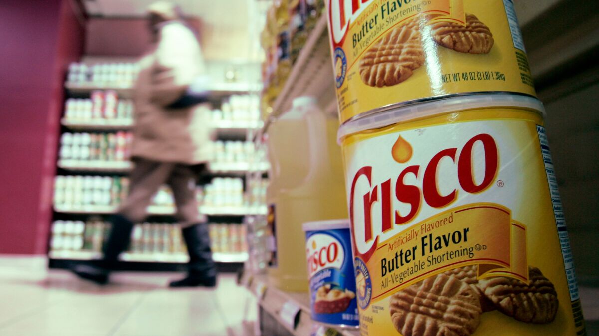 Consumption of vegetable oils, which were invented in the early 1900s, exploded during the 20th century. Above, a shopper walks past an aisle featuring Crisco products in a grocery store in Cleveland, Ohio in 2007.