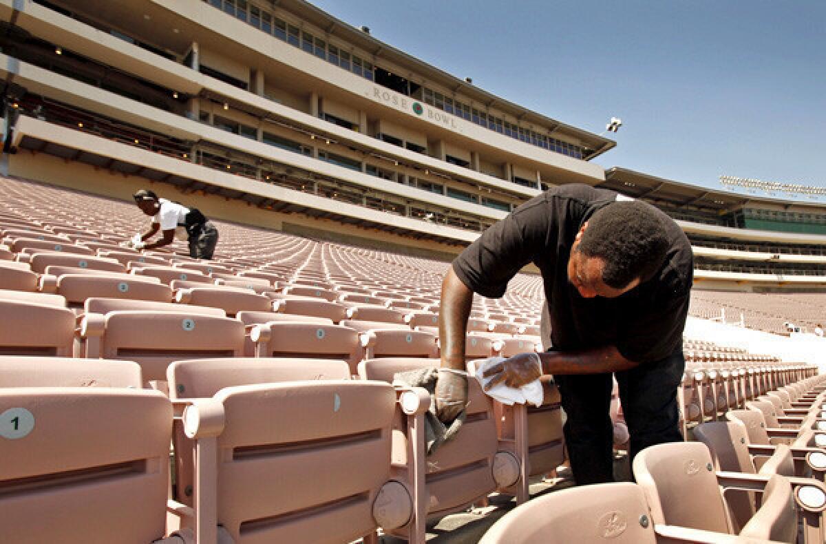 Workers clean the seats below the Rose Bowl's renovated pavilion.