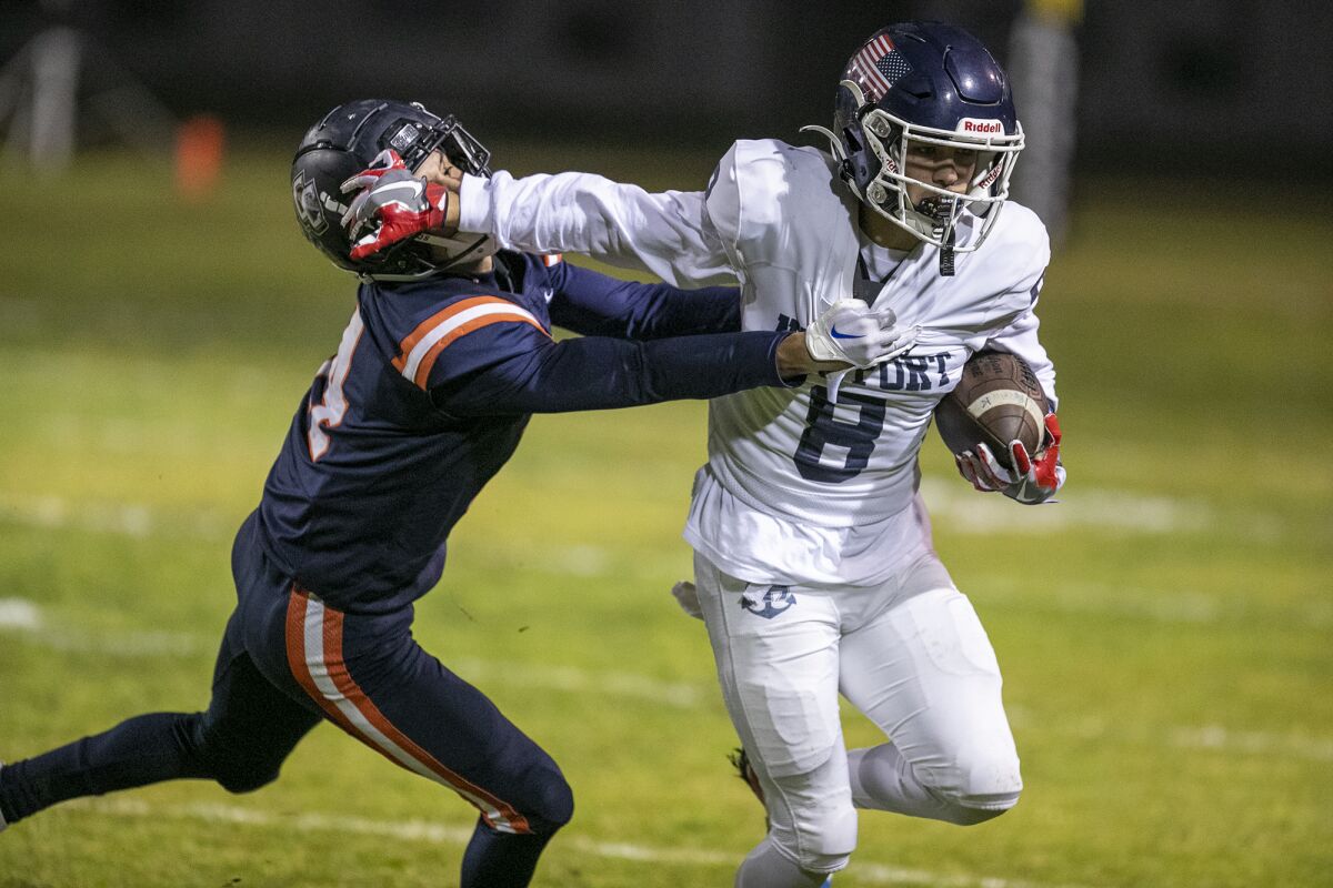 Newport Harbor's Josiah Lamarque stiff arms Cypress' Bobby Castillo on Nov. 18, 2022.