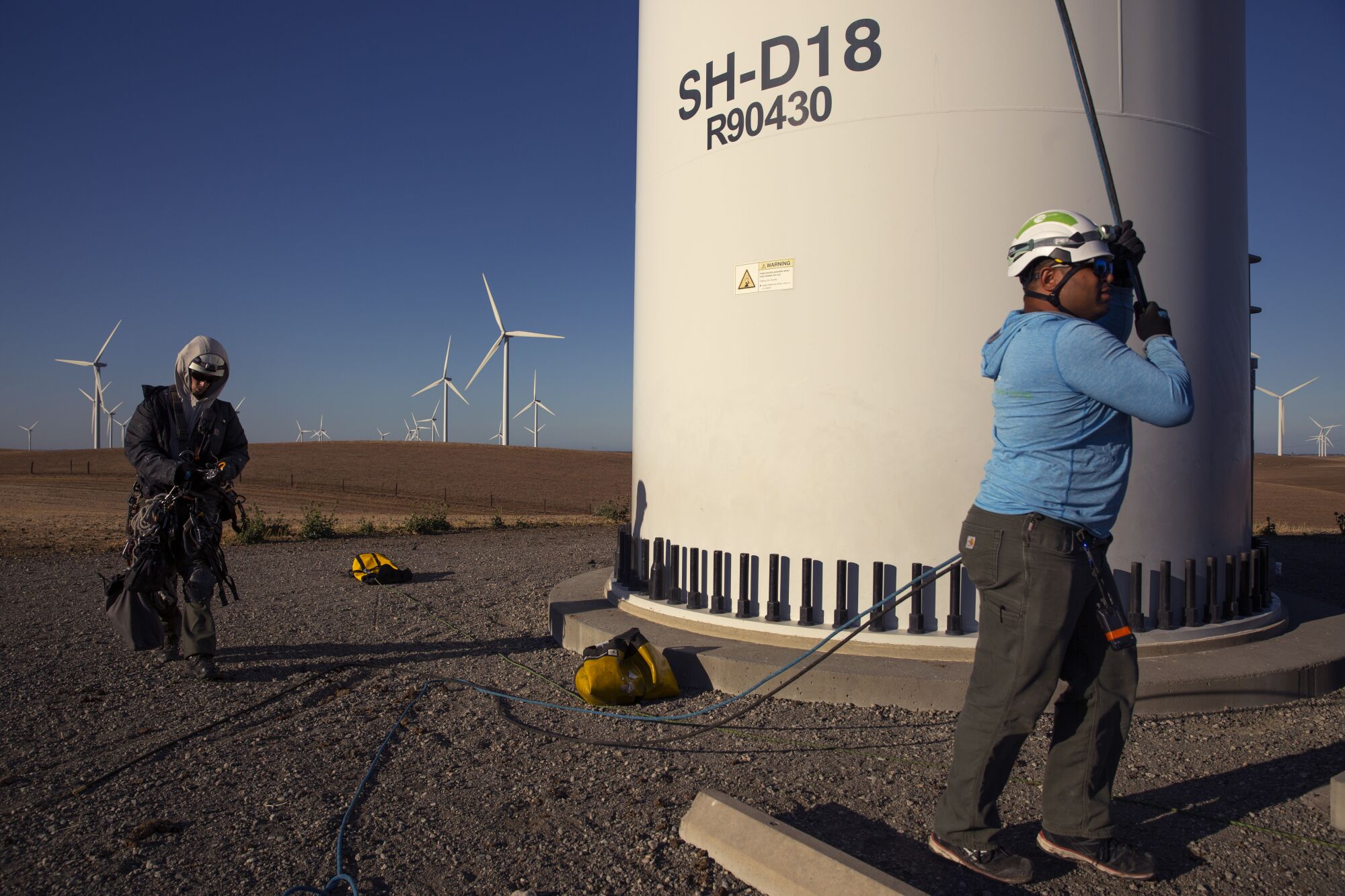 Two people at a wind turbine.