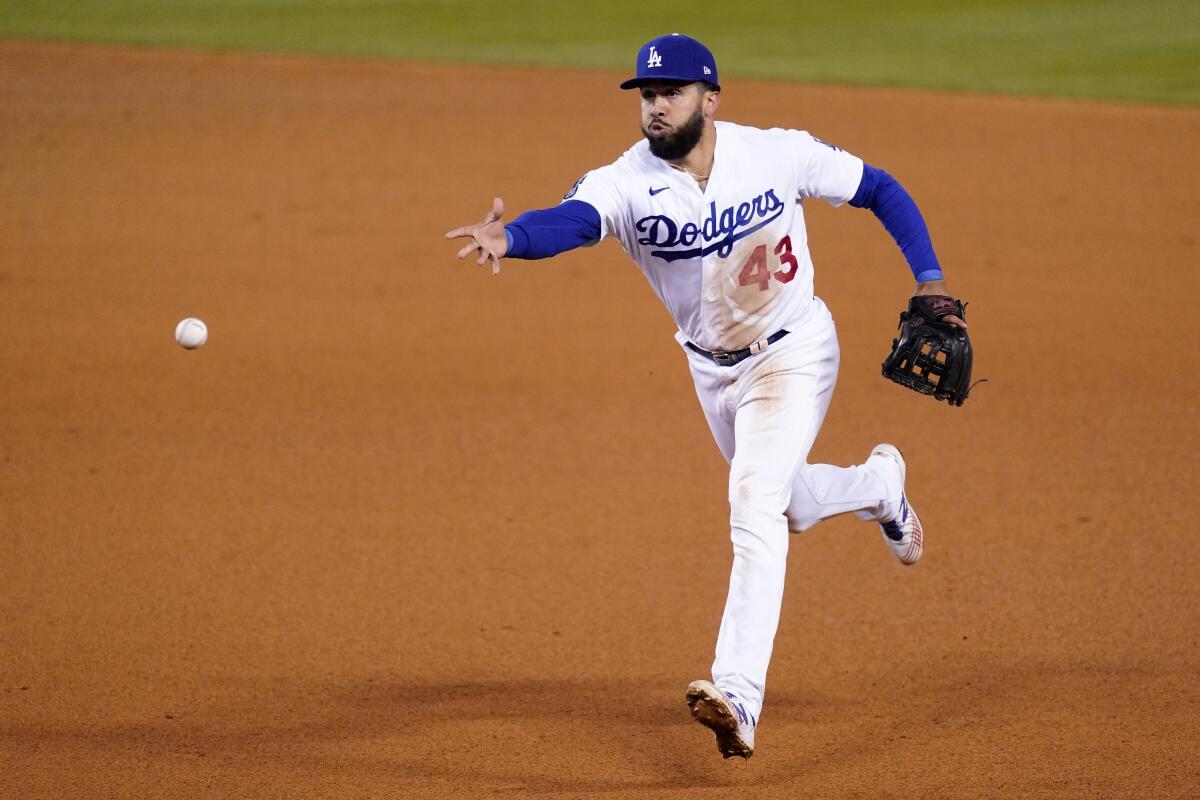 Dodgers third baseman Edwin Rios tosses the ball to first during a game against the Reds on April 26.