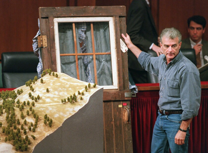 FILE - Randy Weaver holds the door of his cabin showing holes from bullets fired during the 1992 siege of his Ruby Ridge, Idaho, home, model at left, during testimony before the Senate Judiciary Subcommittee on Capitol Hill in Washington on Sept. 6, 1995. Weaver had died at the age of 74. The Ruby Ridge standoff left three people dead and served as a spark for the growth of anti-government extremists. (AP Photo/Joe Marquette, File)