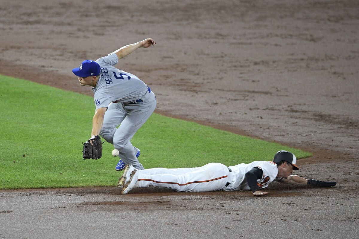 Baltimore's Austin Hays slides into second base as Dodgers shortstop Corey Seager can't catch the pickoff throw during Wednesday's 7-3 loss.