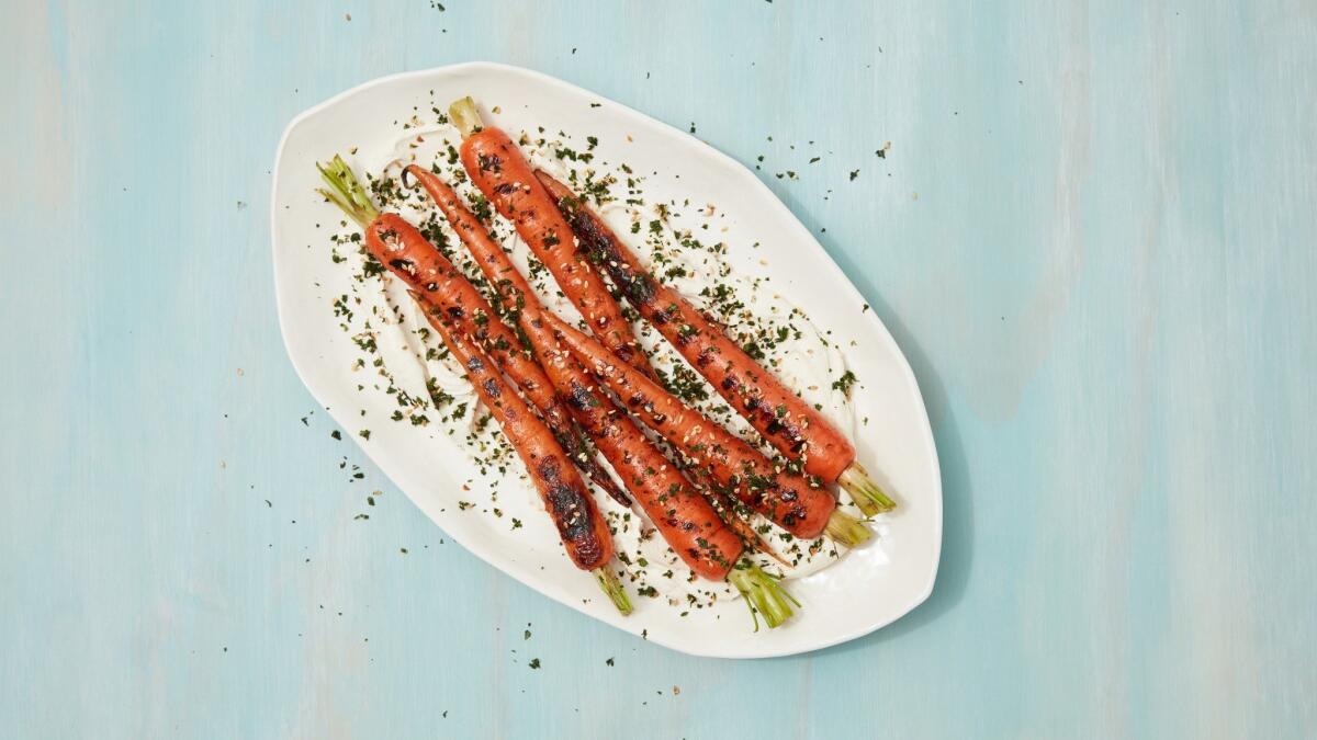 Grilled spring carrots served on a bed of tahini labneh sauce and sprinkled with fresh za'atar made with the carrot tops. Styled by Genevieve Ko at PropLink Studio in downtown Los Angeles..