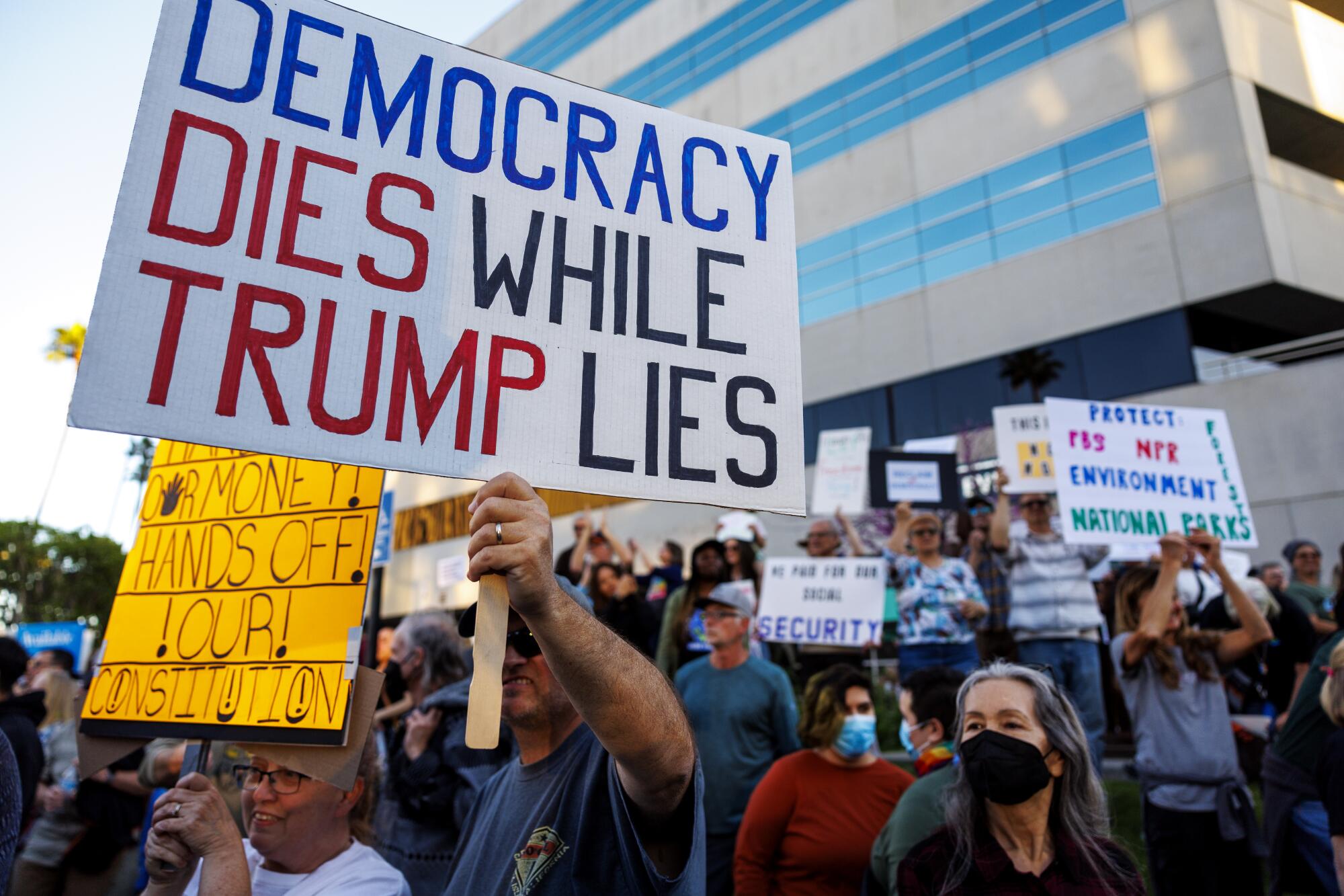Protesters hold signs