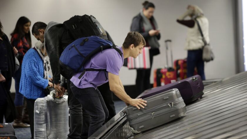 A traveler gathers his luggage at the San Francisco International Airport. Checked bag fees increased Friday at United Airlines, only a week after JetBlue raised its checked bag fees.