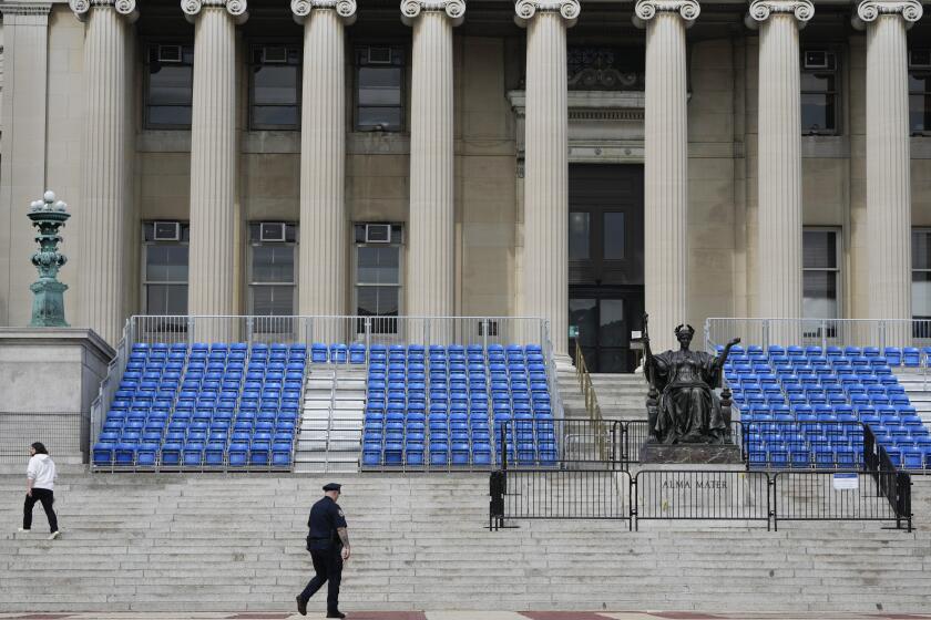 Un agente de la policía de la ciudad de Nueva York camina el lunes 6 de mayo de 2024 frente a unos asientos que serán utilizados para una ceremonia de graduación en la Universidad de Columbia, en Nueva York. (AP Foto/Seth Wenig)