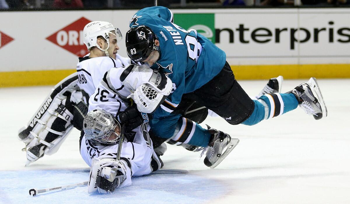 San Jose Sharks' Matt Nieto, right, collides with Kings' Brayden McNabb, left, and Jonathan Quick, bottom, in the second period in Game 4 of the first-round Western Conference playoffs on April 20.