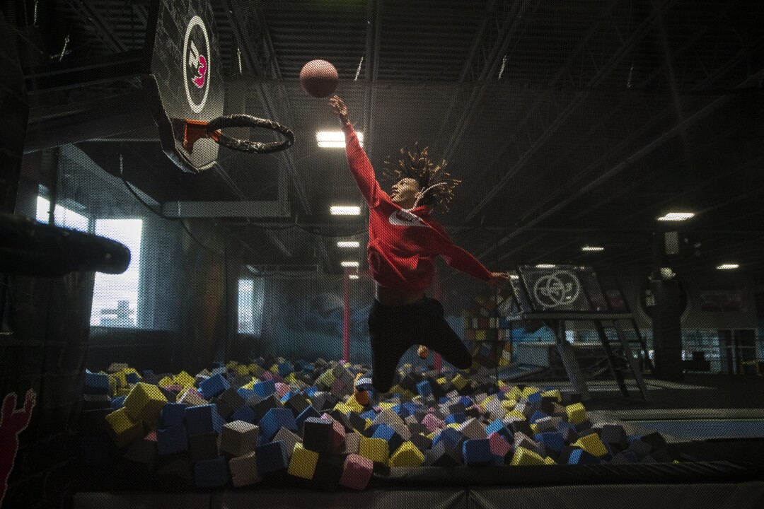 Taevion Rushing flies to the basket as he and his Flint teammates play at a local trampoline park during a snow day.