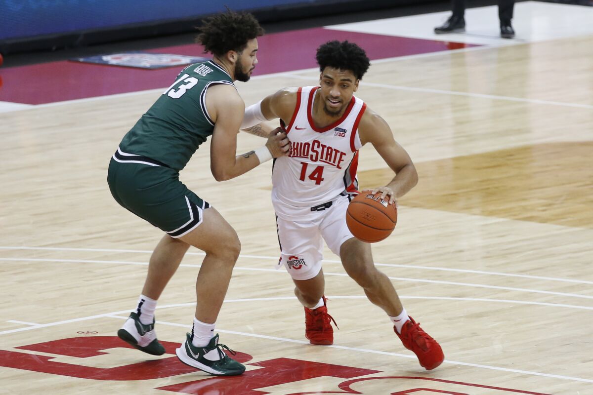 Ohio State's Justice Sueing, right, drives to the basket against Cleveland State's Chris Greene during the second half of an NCAA college basketball game Sunday, Dec. 13, 2020, in Columbus, Ohio. (AP Photo/Jay LaPrete)