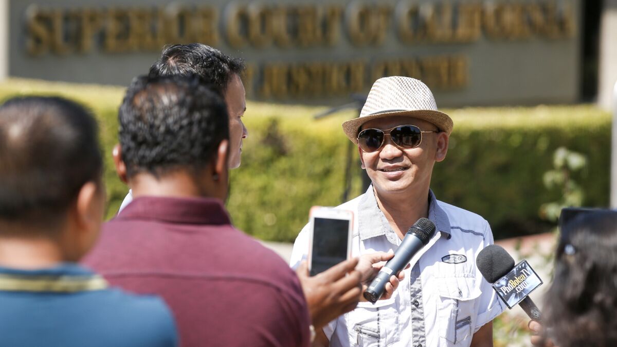 Thien Thanh Nguyen speaks with the Vietnamese-language media outside the West Justice Center in Westminster after a pretrial hearing for his nephew Minh Quang Hong, a popular TV personality in Vietnam who is accused of molesting a boy.