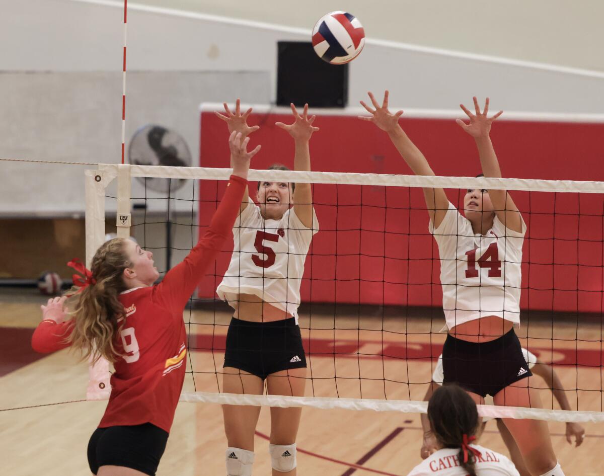Cathedral Catholic's Madyson McCarthy hits past Torrey Pines' Emery Gonzales, left, and Sara Dahl 