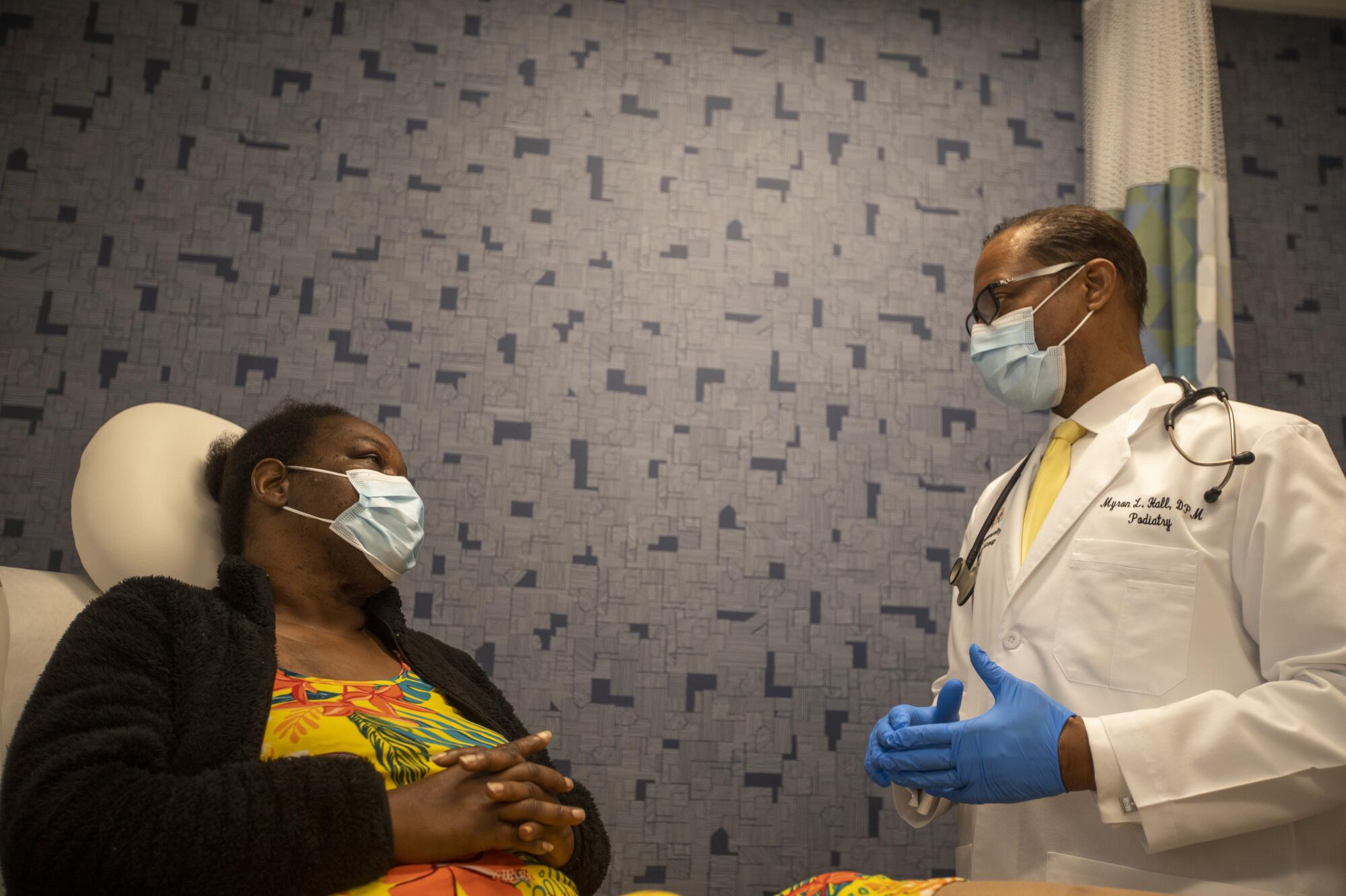 Dr. Myron Hall and patient Glory Paschal discuss her health.