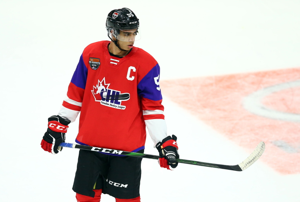 Quinton Byfield on the ice holding a hockey stick.