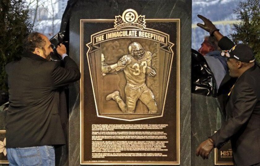 Franco Harris, left, and Frenchy Fuqua unveil a monument commemorating the Immaculate Reception, which took place on Dec. 23, 1972, during a playoff win over the Oakland Raiders.