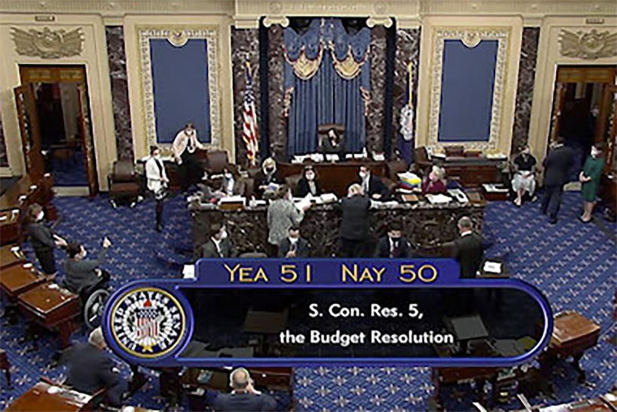 A TV image of the Senate floor and a vote tally on screen reading, "Yea 51, Nay 50"