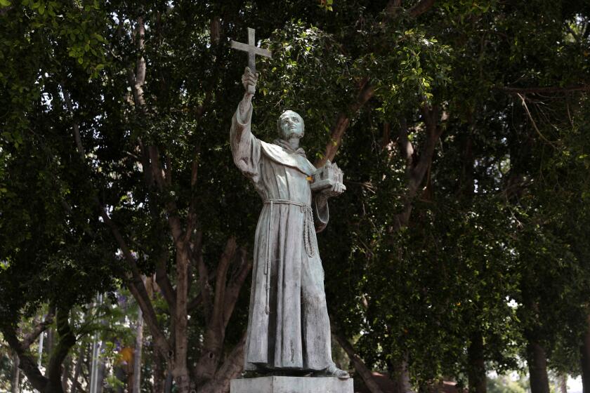 LOS ANGELES, CA - JUNE 20: Activists topple and deface with red paint the statue of Father Junipero Serra (1713 - 1784) at Father Serra Park in Pueblo Amigo on Saturday, June 20, 2020 in Los Angeles, CA. Junipero Serra, a Roman Catholic Spanish priest, who found the first nine of 21 Spanish missions in California from San Diego to San Francisco, in what was then Alta California in the Province of Las Californias, New Spain. (Gary Coronado / Los Angeles Times)