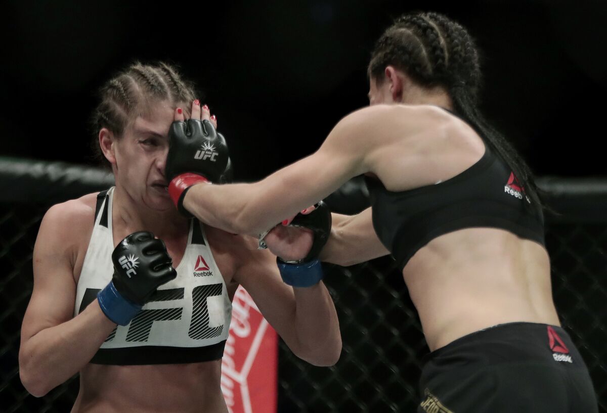 Joanna Jedrzejczyk lands a punch to the face of Karolina Kowalkiewicz during their strawweight title fight at UFC 205.