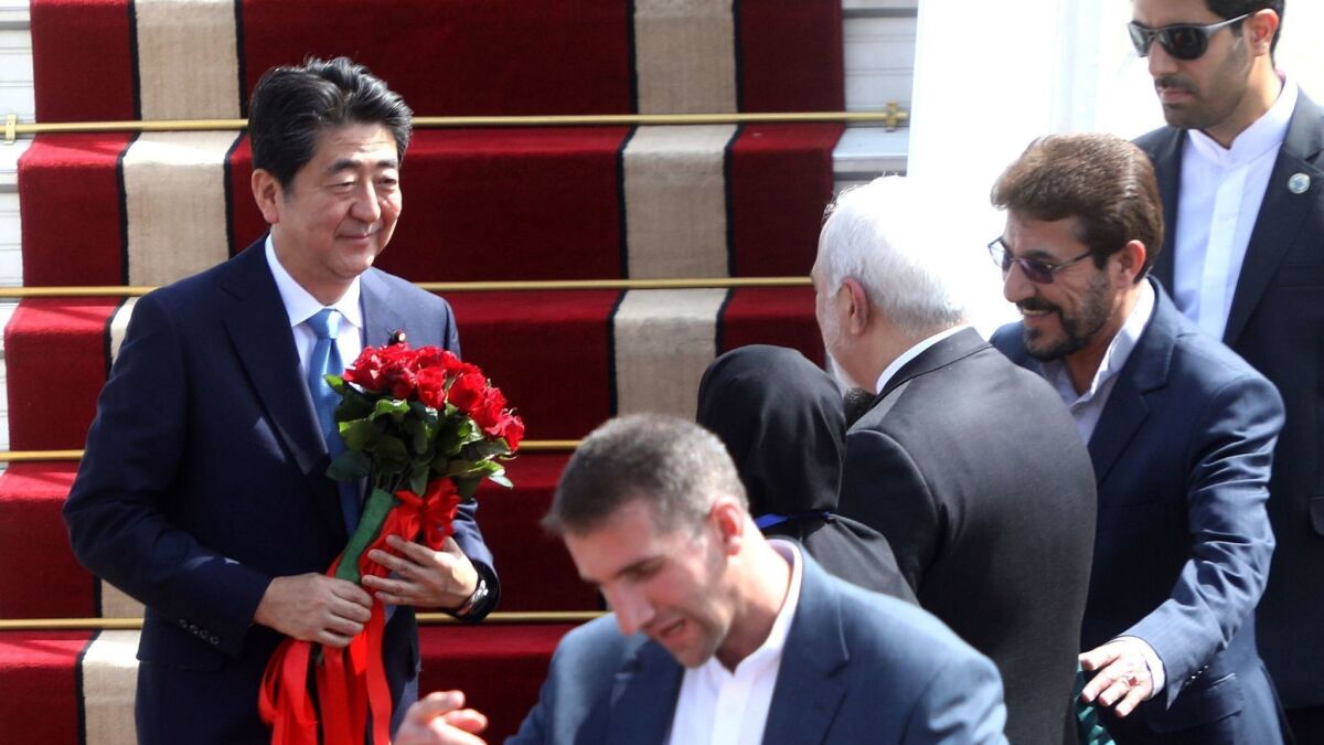 Japanese Prime Minister Shinzo Abe is greeted by Iranian Foreign Minister Mohammad Javad Zarif at Tehran's Mehrabad International Airport on Wednesday.