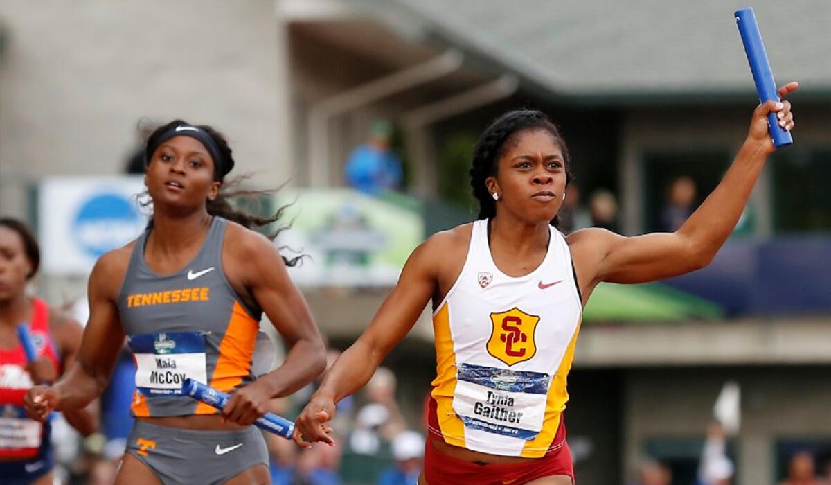USC sprinter Tynia Gaither crosses the finish line in front of Tennessee's Maia McCoy during a women's 400-meter relay semifinal at the NCAA outdoor championships.