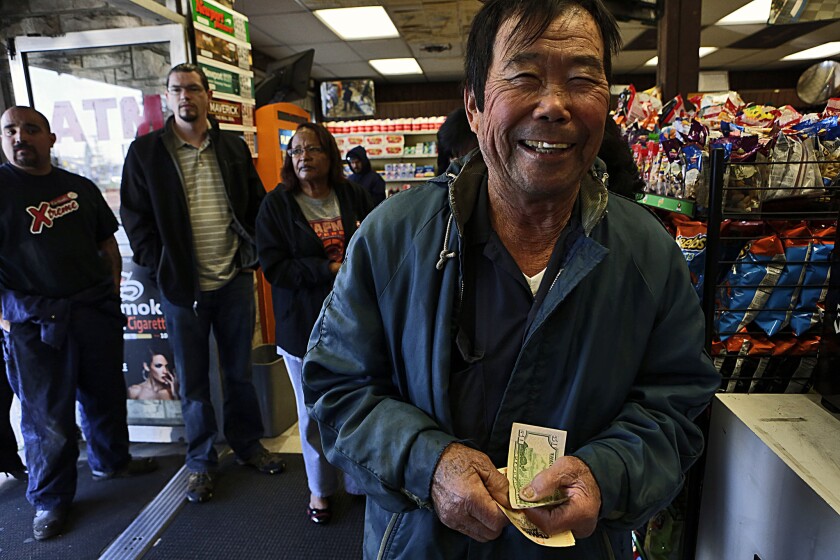 Yutaka Yufuku stands in line to purchase lottery tickets at Bluebird Liquor in Hawthorne. The store has sold winning jackpot tickets in the past and is a favorite of hopeful ticket buyers.