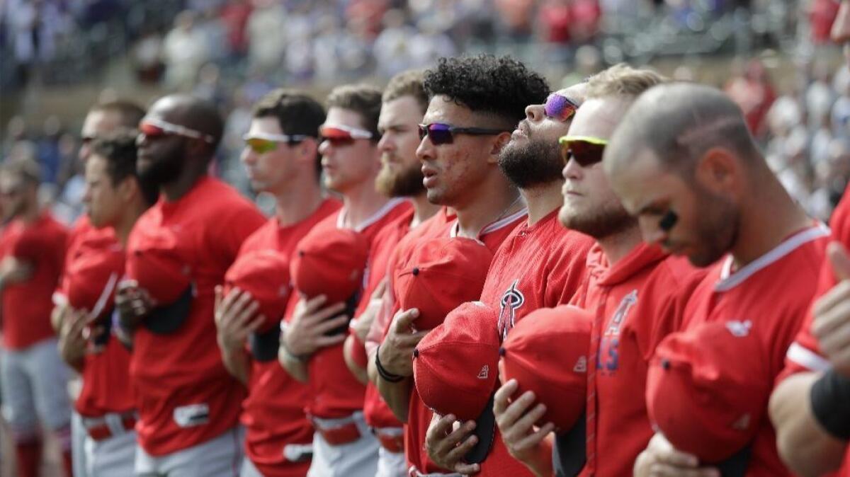 Angels players line up during the national anthem before a spring training game in Scottsdale, Ariz.