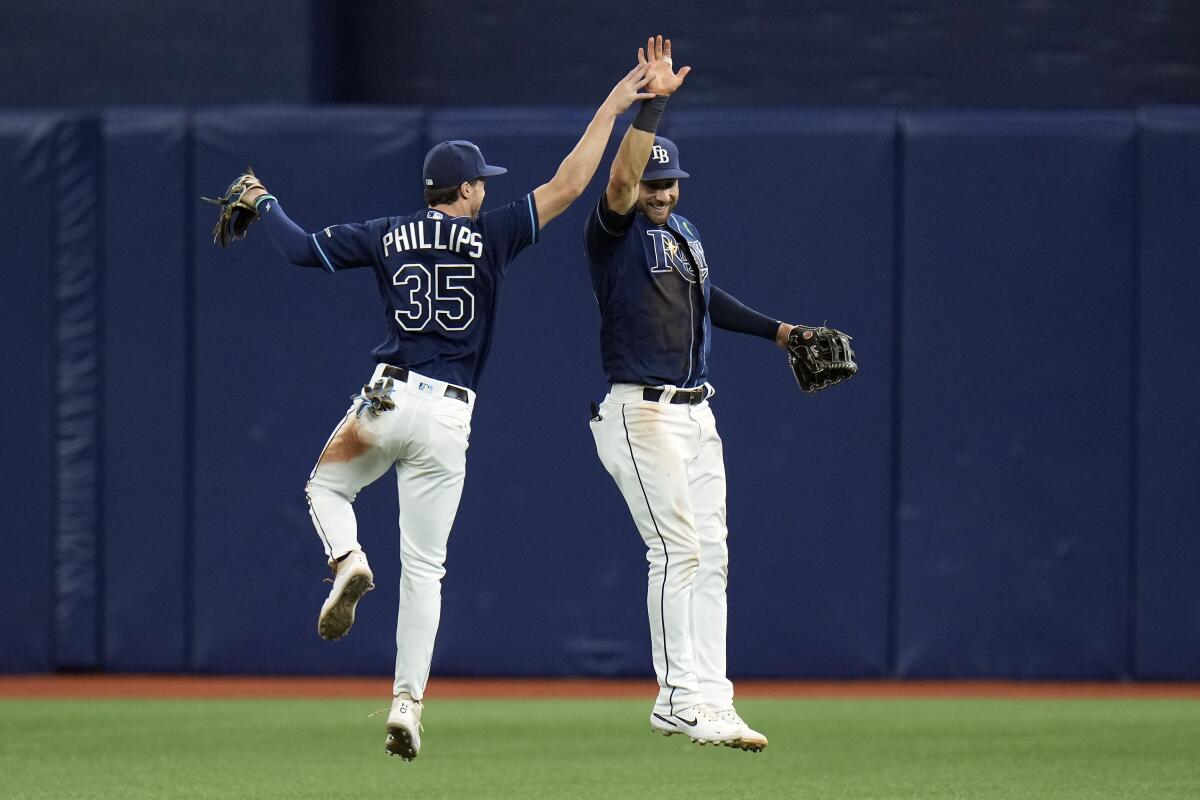 Tampa Bay Rays right fielder Brett Phillips (35) and center fielder Kevin Kiermaier (39) celebrate after the team defeated the Detroit Tigers during a baseball game Tuesday, May 17, 2022, in St. Petersburg, Fla. (AP Photo/Chris O'Meara)