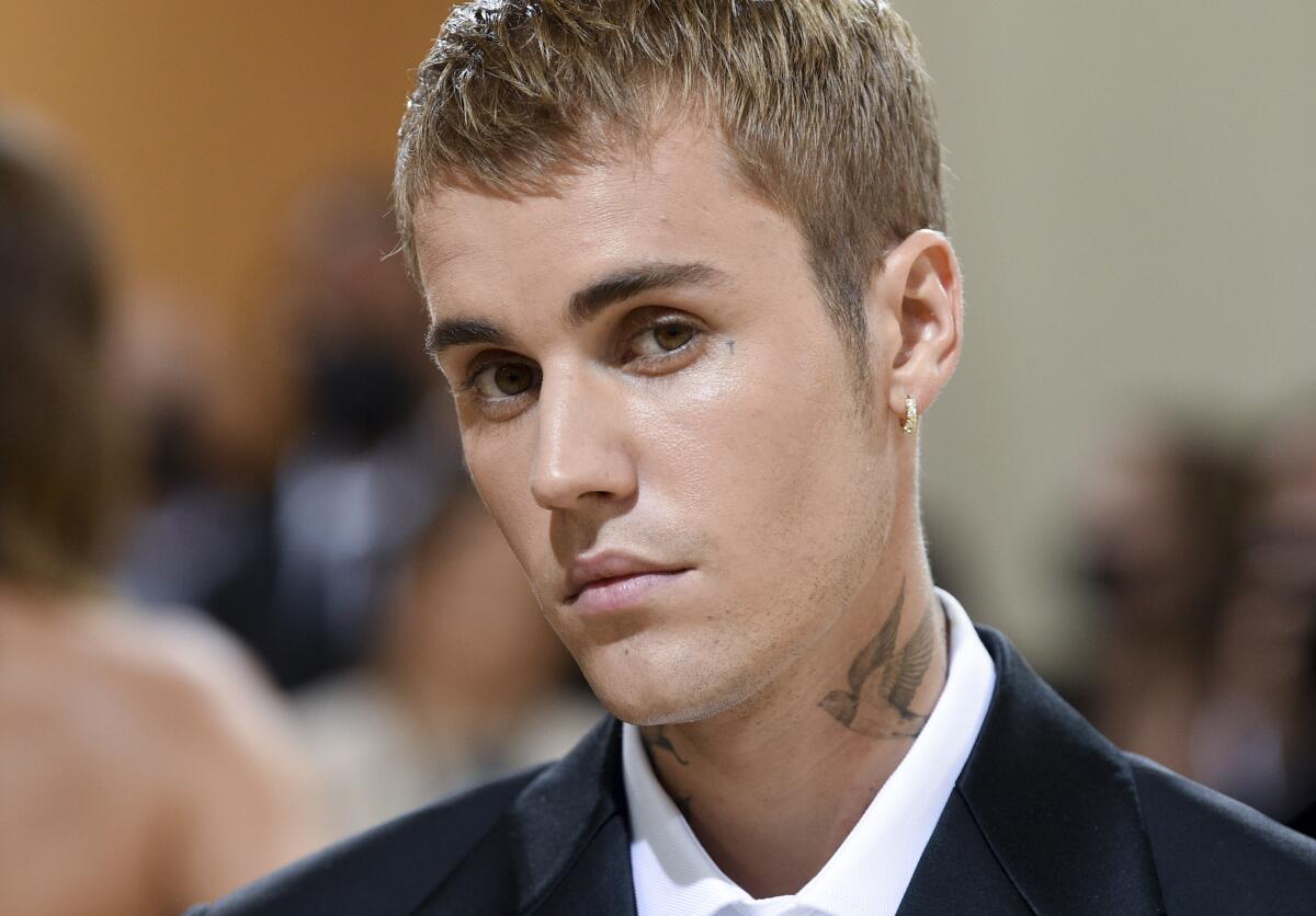 Close-up of a blond man with a bird tattoo on his neck